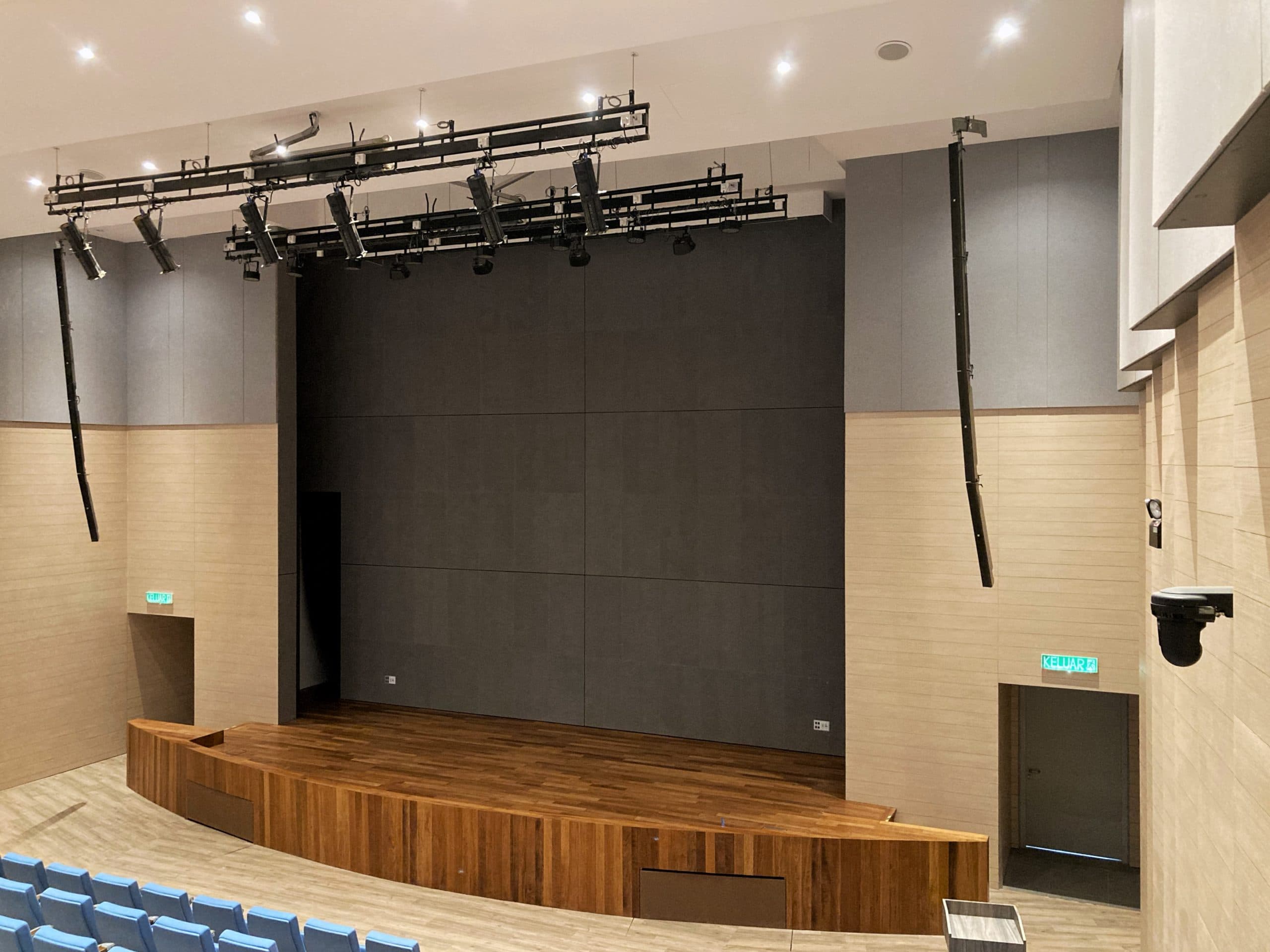 Wide view of one of the school auditoriums, with line-array loudspeakers positioned to keep speech and music intelligible from front row to back.